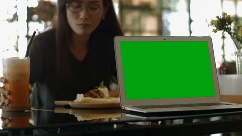 A laptop computer with a key green screen set on coffee shop. Video stock 112372346