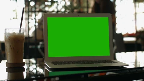 A laptop computer with a key green screen set on coffee shop. Video stock 112372400