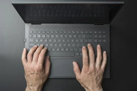 Laptop computer keyboard with user or gamer hands on black stylish background Stock Photos
