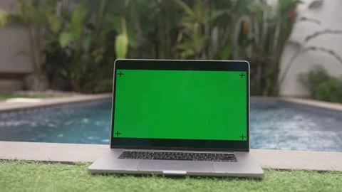 Laptop computer lying on the banks of the pool, slow motion shot Stock Footage 229106945