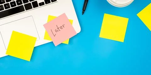 Laptop computer with many sticky notes on a blue background, flat lay. Stock Photos