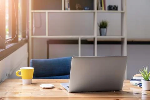 Laptop computer mockup on wooden table with morning light. Stock Photos