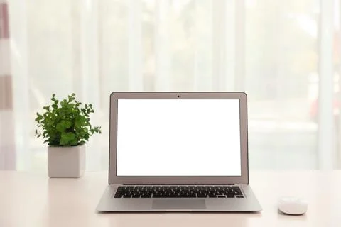 Laptop with computer mouse on table indoors. Space for text Stock-Fotos