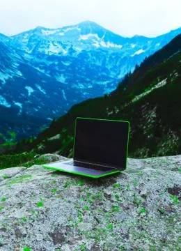 Laptop computer at the natural mountain background. Photo depicts notebook co Stock Photos