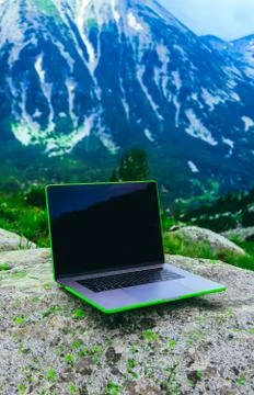 Laptop computer at the natural mountain background. Photo depicts notebook co Stock Photos