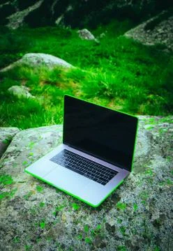 Laptop computer at the natural mountain background. Photo depicts notebook co Stock Photos