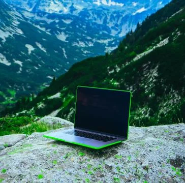 Laptop computer at the natural mountain background. Photo depicts notebook co Stock Photos