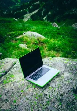 Laptop computer at the natural mountain background. Photo depicts notebook co Stock Photos