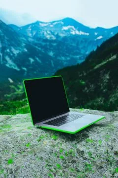 Laptop computer at the natural mountain background. Photo depicts notebook co Stock Photos