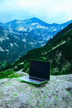 Laptop computer at the natural mountain background. Photo depicts notebook co Stock Photos