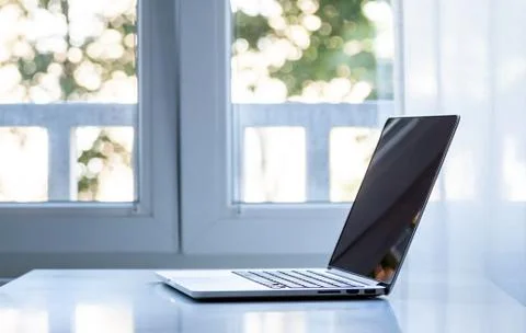 Laptop computer near the window Stock Photos