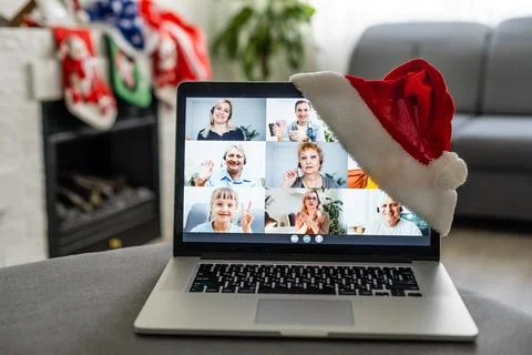 Laptop computer standing on table with gift and Santa hat in cozy room, Merry Stock-Fotos