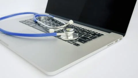 A Laptop Computer with Stethoscope Lying on Top Stock Photos