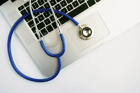 A Laptop Computer with Stethoscope Lying on Top Stock Photos