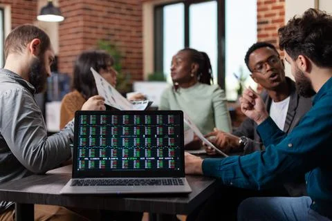 Laptop computer with stock data on screen standing on table Stock Photos