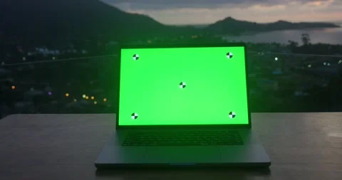 Laptop computer on a table with a green background mockup on background of Stock Footage 238679560