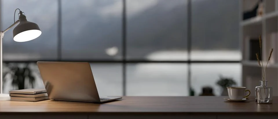 A laptop computer, a table lamp, and decor on a wooden desk in a modern, lu.. イラスト素材