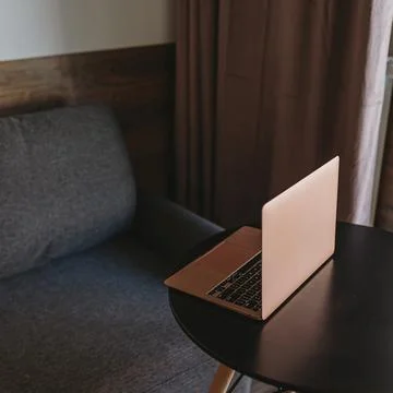 Laptop computer on table near comfortable sofa Stockfoto's