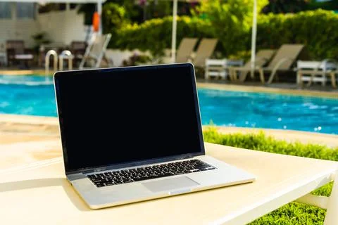 Laptop computer on table pool background Stock Photos