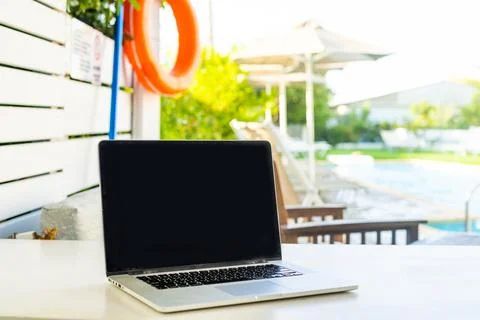 Laptop computer on table pool background Stock Photos