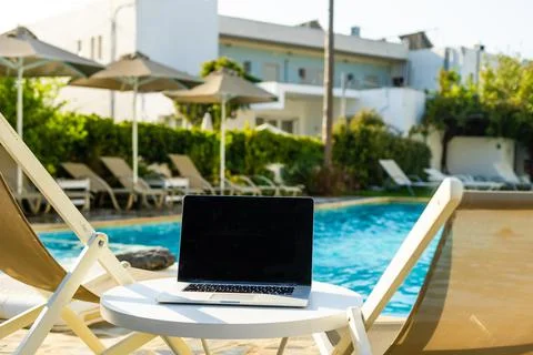 Laptop computer on table pool background Stock Photos