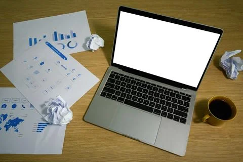 Laptop computer with white empty display, reports, crumpled papers and coffee Stock Photos