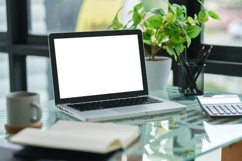 Laptop computer with white empty display, calculator and coffee cup on offi.. Stock Photos