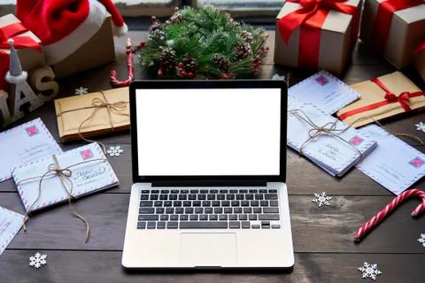 Laptop computer with white mock up screen monitor on Merry Christmas table. Stock Photos