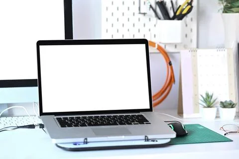 Laptop computer with white screen on graphic designer workspace. Stock Photos