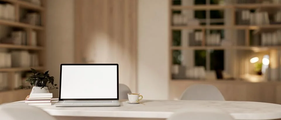 A laptop computer with a white-screen mockup on a white marble table in a c.. イラスト素材