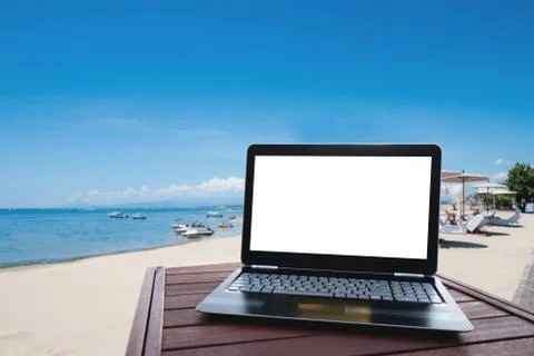 Laptop computer on wood table at the beach in summer Stock Photos