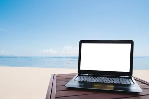 Laptop computer on wood table at the beach in summer Stock Photos