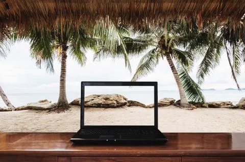 Laptop computer on wooden table with at the beach Stock Photos