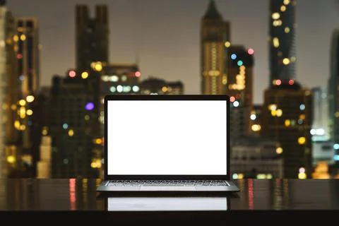 Laptop computer on workspace white blank screen display city on Stock Photos