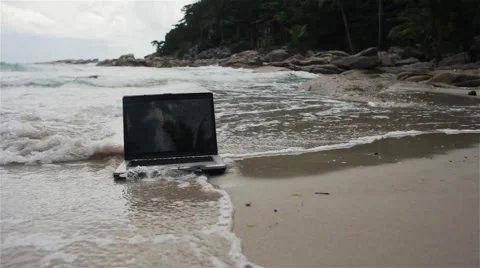 Laptop is covering with water on the beach 動画素材 59382817