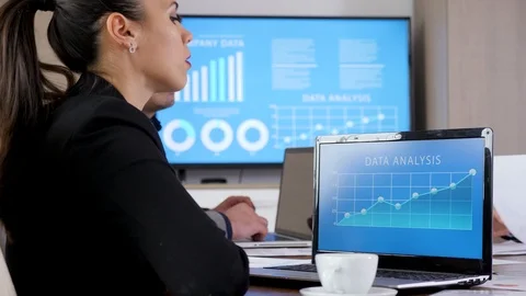 Laptop with data analysis in front of business woman Stock Footage 97587423