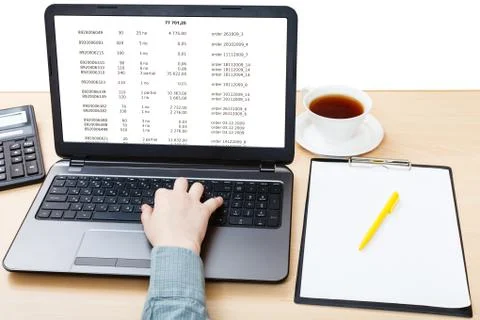 Laptop with data on screen on office table Stock Photos