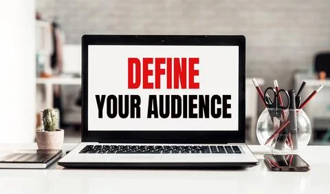 Laptop with DEFINE YOUR AUDIENCE text on modern office background. Stock Illustration