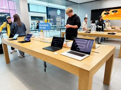 Laptop display in a modern electronics Apple store with students and shoppe.. Stock Photos