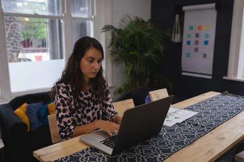 Laptop displaying chart data and documents lying on wooden table with blue Foto stock