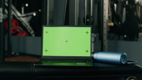 Laptop Displaying Chroma Key Green Screen with Tracking Markers in Gym Stock Footage 345201473