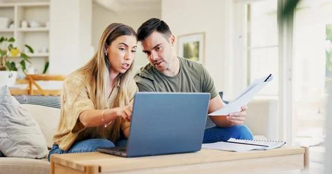 Laptop, documents and couple on sofa in home for discussion on monthly budg.. Stock Photos