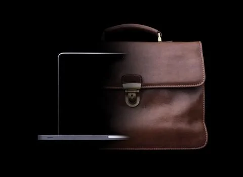 A laptop in expensive leather briefcase on a black background. Stock Photos