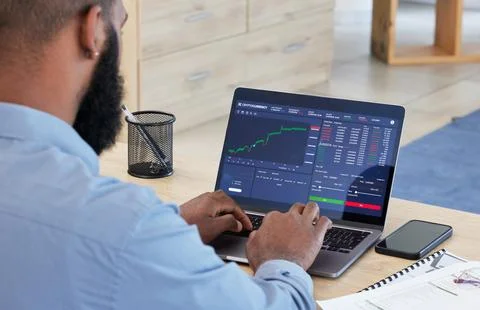 Laptop, finance and stock market with a man broker working in his office for Stock Photos