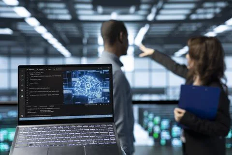 Laptop in front of data center AI technicians in blurry background 스톡 사진