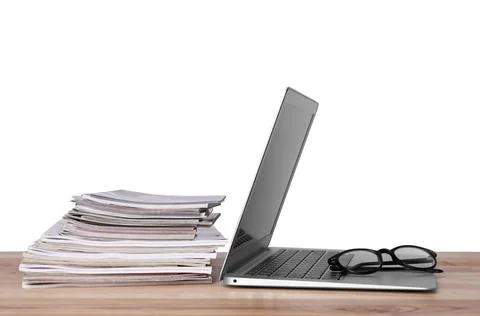 Laptop, glasses and stack of magazines on wooden table 스톡 사진