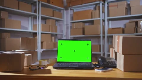 Laptop with a green screen on the background of a warehouse with parcels in 스톡 동영상 270893333