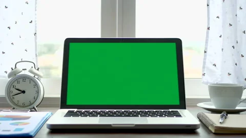 Laptop with a green screen chroma key set on work office table near the window Stock Footage 133409162