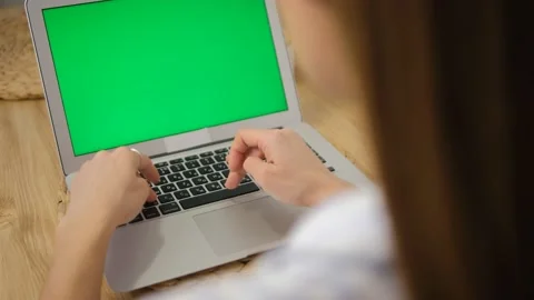 A laptop with a green screen. Close-up of hands working on the keyboard. Remote  Stock Footage 149608257