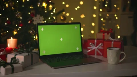 Laptop with green screen. Computer with chroma key on table, burning candle a Stock Footage 220788149